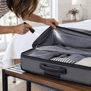 woman checking luggage for bed bugs after traveling